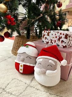 two crocheted santa claus slippers sitting on the floor next to christmas presents