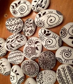 some rocks with designs on them sitting on a table