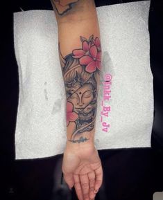 a woman's arm with a buddha tattoo on the left side of her hand