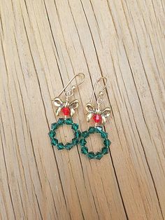 These adorable Christmas Wreath Earrings are Handmade with Emerald Green and Red Swarovski Crystal Bicone Beads and Tierra Cast, Lead-Free Pewter Bow Beads. 14K Gold Filled Ear Wire by Tierra Cast has been used. Meticulously wire wrapped with Tarnish Resistant 14k Gold Plated Wire. Charming yet attractive Holiday Earrings. You just have to pick up a pair of these delightful Holiday Earrings. Great gift for girls and women who love Christmas Jewelry. Earring Detail / Measurements * 14k Gold Fille Christmas Wreath Earrings, Bow Beads, Wreath Earrings, Earrings Emerald, Holiday Earrings, Jewelry Earring, Holiday Earring, Holiday Jewelry, Green And Red