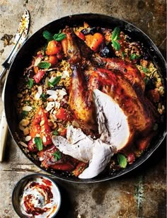 a pan filled with chicken and vegetables on top of a table