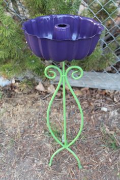 a purple flower pot sitting on top of a metal stand