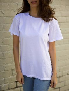 Our Classic White Unisex Tee is made from an extremely soft, lightweight jersey out of 100% cotton fibers. Style details include a crew neck and clean finished hems. Classic fit. Additional Information: * 100% Cotton * Made in USA * Length: 25 3/4 in. (XS) * Model wears size XS * Machine wash cold with like colors, tumble dry low * This item is unisex sizing. We recommend men order their normal size and women size down for a more fitted look Look Plus, Classic White, Cotton Fiber, Unisex T Shirt, Made In Usa, Bathing Beauties, Adult Outfits, Womens Sizes, Angeles