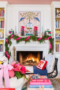 a living room decorated for christmas with pink and green decorations on the fireplace mantel