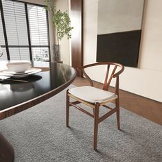 a dining room table with chairs and a vase on the top, in front of a large window