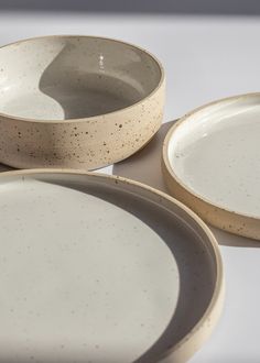 three white and brown dishes sitting on top of each other