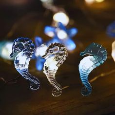 three seahorses sitting on top of a table next to each other with lights in the background