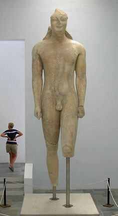 a woman standing next to a statue in a museum