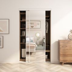 an empty room with white walls and wooden furniture, including a large mirrored closet door