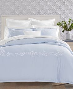 a white bed with blue comforter and pillows