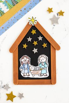 a nativity scene is displayed on a table with stars and confetti around it