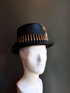 Make a bold statement with this Bullet Band Steampunk Top Hat, featuring a unique combination of brass bullets and feathered accents. Perfect for steampunk enthusiasts, costume parties, and themed events, this hat captures a rugged yet stylish aesthetic. The mix of industrial bullets with elegant feathers makes this hat a standout piece for any occasion.  Age Group/Gender - Adult/Men  Size/Type - One size fits all adults  Mask Color - Black/Brown  Mask Material - Vegan leather  Special Features Mardi Gras Kid, Kids Party Packs, Steampunk Top, Steampunk Top Hat, Female Mask, Stylish Aesthetic, Costume Parties, Themed Events, Best Couple