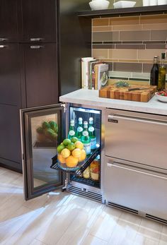 an open refrigerator in a kitchen filled with fruits and vegetables next to a counter top