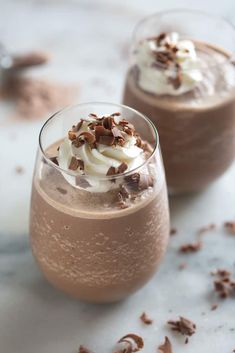 two glasses filled with chocolate pudding and whipped cream