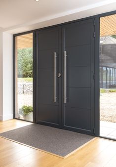 a modern entry with double doors and wood flooring