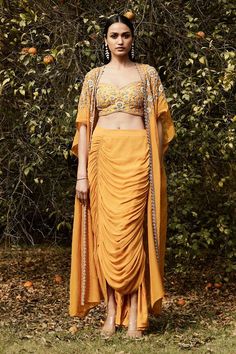 Orange long cape with floral, sequins, cutdana and moti hand work. Comes with embroidered, padded blouse and draped dhoti skirt. - Aza Fashions Dhoti Skirt, Mehandi Outfits, Floral Cape, Trendy Outfits Indian, Outfits Indian, Long Cape, Padded Blouse, Dhoti Pants, Dresses Indian