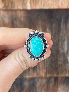 This Sterling ring is a size 5 1/2 but it has a slight bend in the band so it could pass for a 6,  it just depends which way it is twisted on the ring sizer.  The band is solid in back but fans out into three pieces right near the front. The oval centerpiece is Turquoise with a light speckled pattern and it is surrounded by a twisted metal border. The setting is very pretty with subtle scroll work and metal dots. The inside of the band is stamped, 'Sterling' and there is a hallmark right next to it but I am not sure of the maker. The metal has been left unpolished. Untreated Oval Turquoise Ring, Western Style Oval Gemstone Rings, Oval Gemstone Western Rings, Untreated Oval Turquoise Ring For Anniversary, Untreated Adjustable Oval Turquoise Ring, Adjustable Turquoise Oval Rings, Southwestern Oval Turquoise Ring Stamped 925, Adjustable Oval Turquoise Ring With Patina, Western Style Untreated Oval Turquoise Ring