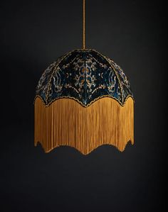 a blue and gold chandelier with fringes hanging from it's sides