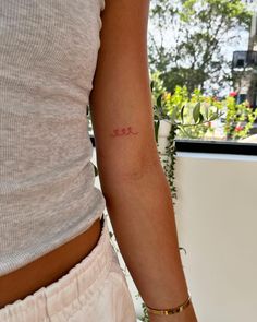 a woman's arm with a small tattoo on the left side of her arm