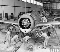 men working on an airplane in a hangar