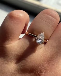 a person's hand with a ring on it and a diamond in the middle