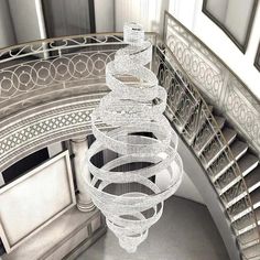 a large chandelier hanging from the ceiling in a room with white walls and stairs