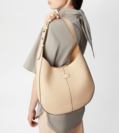 The timeless elegance of the Di Bag style is declined in a hobo version with sober and essential lines. Crafted in calfskin leather, it comes with an adjustable shoulder handle and the characteristic Tod's logo stamped on the front. Complemented by a removable internal pouch, it accompanies your everyday outfits with class and femininity. Everyday Luxury Beige Calf Leather Shoulder Bag, Timeless Beige Calf Leather Bag, Timeless Textured Leather Bag For Everyday Luxury, Elegant Calf Leather Shoulder Bag With Smooth Grain, Classic Textured Leather Shoulder Bag For Everyday Luxury, Timeless Soft Leather Shoulder Bag, Leather Hobo Bag With Leather Lining For Work, Beige Calf Leather Bag, Timeless Beige Textured Leather Shoulder Bag