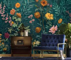 a blue chair sitting in front of a green wall with flowers painted on the walls