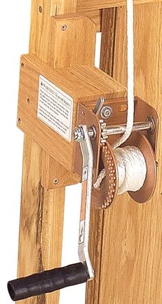 a close up of a wooden door with a rope and spool attached to it