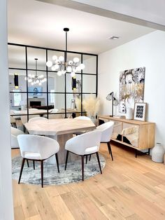 a dining room table with white chairs around it