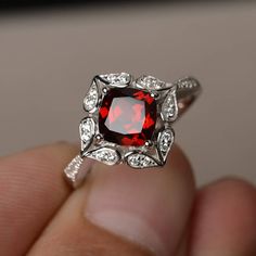 This is a gorgeous handmade creation. Its beauty is its simplicity & Elegance. The 7*7 mm cushion shape faceted natural garnet is crafted in solid sterling silver and with rhodium plated. All item is sent in a beautiful gift box If you have any idea of design your ring,pls contact me directly. You can realize more lovely stuff clicking the link https://www.etsy.com/shop/knightjewelry?refshopsection_shophome_leftnav Please leave the correct address and you phone number for delivering successf Elegant Garnet Solitaire Ruby Ring, Elegant Solitaire Garnet Ruby Ring, Elegant Asscher Cut Ruby Ring, Red Cushion Cut Ring With Accent Stones, Red Cushion Cut Ruby Jewelry, Cushion Cut Ruby Ring With Halo Setting, Elegant Red Cushion Cut Ruby Ring, Elegant Cushion Cut Ruby Ring, Wedding Silver Garnet Birthstone Ring