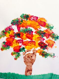 an image of a tree made out of paper and colored flowers on top of it