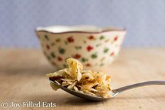 a spoon full of food sitting next to a bowl