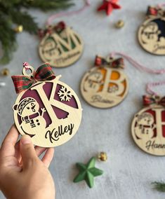 a person holding an ornament in front of christmas ornaments on a table with other ornaments