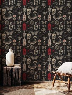 a room with a chair and wallpaper that has skulls on it, along with a vase