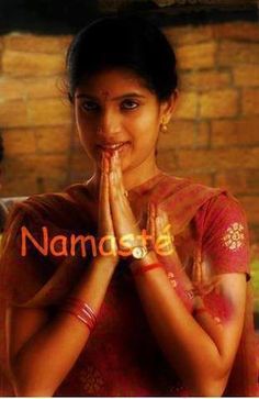 a woman is standing with her hands folded in front of her face and the words namaste above her