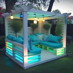 an outdoor living area is lit up with blue and green lights, including a couch