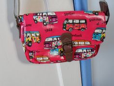 "Here is a great shoulder bag for the lover of the VW Campervan. It is made of bright shocking pink vinyl fabric which is decorated in colourful VW camper van motifs and little sayings, or slogans, reflecting the 1968 \"Summer of Love\" and \"Woodstock\" There is no manufacturer's tag anywhere nor any sign of one. I think it could have been made up to about 20 years ago. The bag has a magnetic popper opening which is made of faux leather and a brass-like metal. It's tight fitting so should not be \"yanked\" to open the flap. On the back the bag has a zipped pocket. The zip is pink. The pocket is lined. Under the bag's closing flap is another pink zip which opens the main part of this shoulder bag. The interior is lined with a nylon fabric which has a zipped pocket and two other pockets. Th Retro Pink Shoulder Bag For Daily Use, Pink Retro Shoulder Bag, Retro Pink Shoulder Bag As Gift, Pink Retro Shoulder Bag As Gift, Cute Red Rectangular Satchel, Vintage Pink Satchel For Everyday Use, Retro Pink Shoulder Bag Satchel, Vintage Pink Crossbody Shoulder Bag, Retro Red School Shoulder Bag