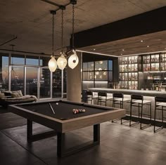 a billiard table in front of a bar with lots of bottles on the shelves