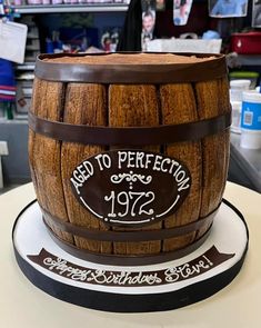 a birthday cake made to look like a wooden barrel with the words aged to perfection written on it