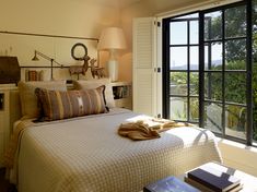 a bedroom with a large bed and two lamps on either side of the window sill