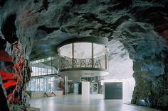 the inside of a cave with a spiral staircase and glass windows on the side wall