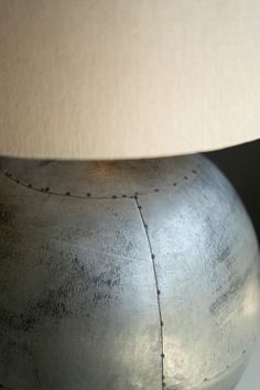 a large metal vase with a white lamp on top