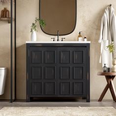 a bathroom with a sink, mirror and towel rack on the wall next to it