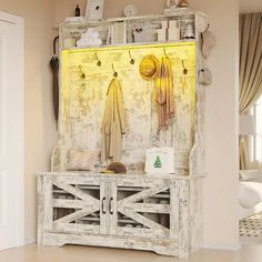 an old wooden cabinet with hooks and umbrellas hanging on the door, in front of a white living room