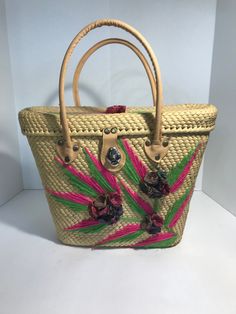 "Vintage 1960s straw handbag purse tote, Vintage embroidered straw handbag tote with applied floral detail. Large straw tote Applied 3-dimensional straw floral details (A couple of the threads are disconnected) Vibrant pink/green embroidered design on front/top of tote Natural leather straps/closure (leather feels/looks like genuine but not 100% sure) Great vintage condition overall Height 10\" Width 14\" Depth 4\" Handles 17\"" Wicker Bags, Straw Handbags, Straw Tote, Handbag Purse, Embroidered Design, Vintage 1960s, Natural Leather, Tote Handbags, Purses And Handbags