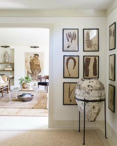 a living room filled with furniture and pictures on the wall next to an open door