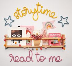 there is a shelf with books and toys on it that says storytime read to me