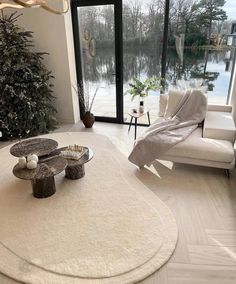 a living room filled with furniture and a large window overlooking the snow covered lake in front of it