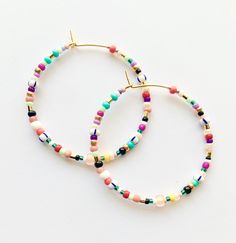 Large and colorful, beaded hoop earrings. Light weight with a bright, summer-y mix of colors. Made with a high quality mix of gorgeous seed beads. ✨Each piece is handmade to order and one-of-a-kind with variations in bead order.✨ Gold plated, 45 mm (1.75 inches) hoops. Looking for smaller sizes? Small Beaded Hoops: https://etsy.me/3bs8SKz Medium Beaded Hoops: https://etsy.me/3xXuyrh 🌎 Packaging 🌎 To be environmentally responsible about packaging we will package orders together in the same box. Seed Bead Hoop Earrings, White Hoop Earrings, Bead Hoop Earrings, Minimalist Necklace Gold, Boho Hoop Earrings, Earrings Tutorial, Polymer Clay Bracelet, Beaded Earrings Diy, Gold Bead Necklace